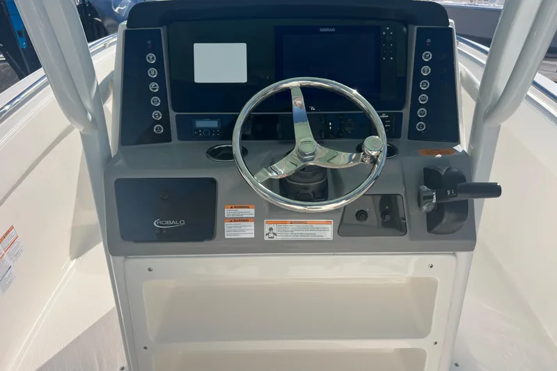 Slide: The Image of 2024 Robalo R232 Explorer boat dashboard with steering wheel and control panel. - 10