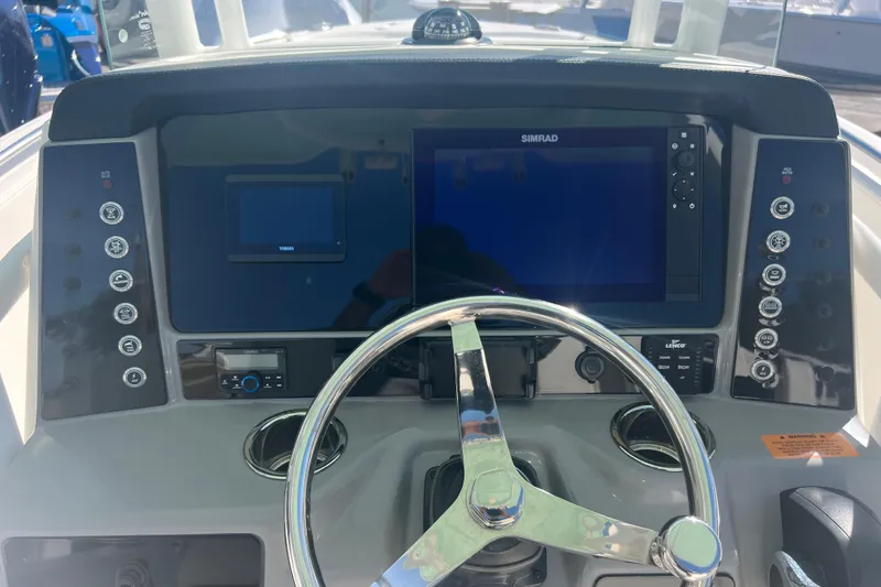 Slide: The Image of 2024 Robalo R232 Explorer dashboard with steering wheel and navigation controls. - 11