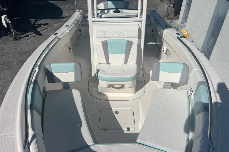 Slide: The Image of 2024 Robalo R232 Explorer boat interior with white and teal seating. - 14