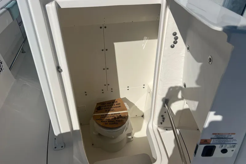 Slide: The Image of 2024 Robalo R232 Explorer boat interior with compact marine toilet. - 16