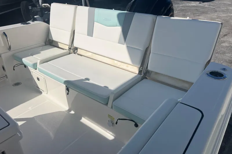 Slide: The Image of 2024 Robalo R232 Explorer boat interior with cushioned seating and storage compartments. - 19