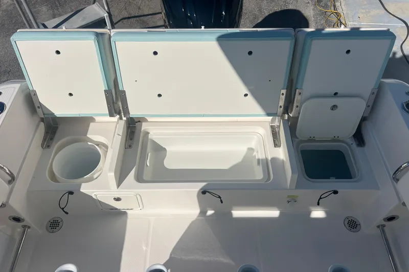 Slide: The Image of 2024 Robalo R232 Explorer boat storage compartments and livewell, open view. - 20