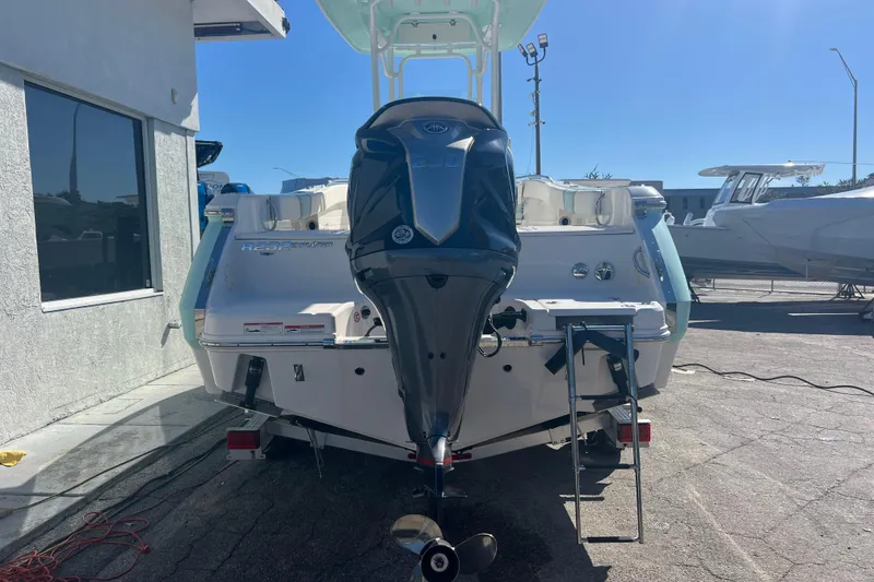 Slide: The Image of 2024 Robalo R232 Explorer boat with outboard motor, parked outdoors. - 4