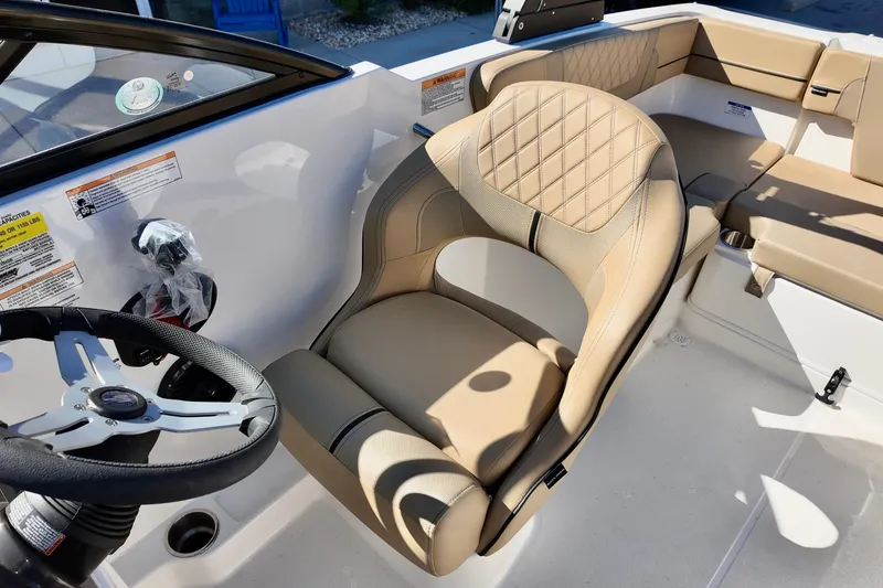 Slide: The Image of 2025 Bayliner VR4 Bowrider OB interior with beige seating and steering wheel. - 4