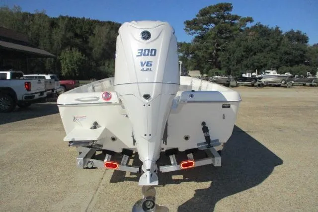 Slide: The Image of 2026 Skeeter SX2350 boat with 300 V6 4.2L engine, parked outdoors. - 18