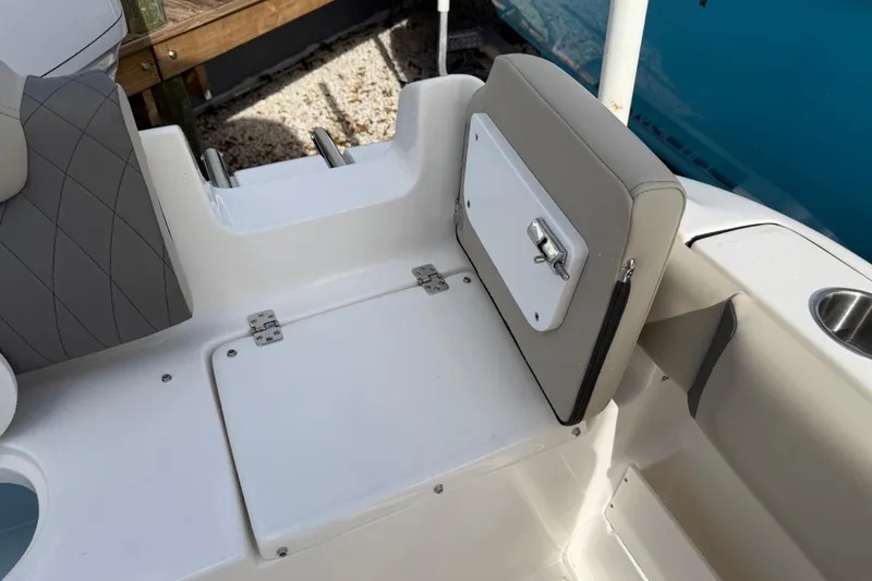 Slide: The Image of 2026 Key West 239 FSR boat seating area with storage compartment and cup holder. - 17