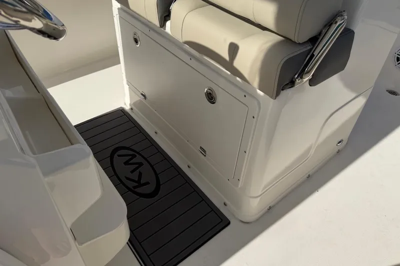 Slide: The Image of 2026 Key West 239 FSR boat interior with cushioned seating and branded floor mat. - 24