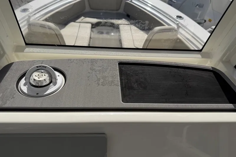 Slide: The Image of 2026 Key West 239 FSR boat interior with compass and seating area. - 32