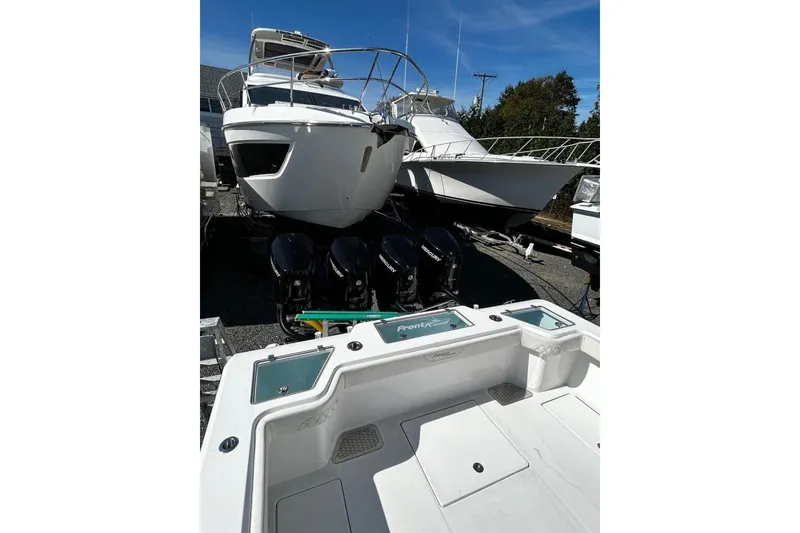 Slide: The Image of 2023 Front Runner 39 Center Console boat with multiple outboard engines, docked alongside other vessels. - 13