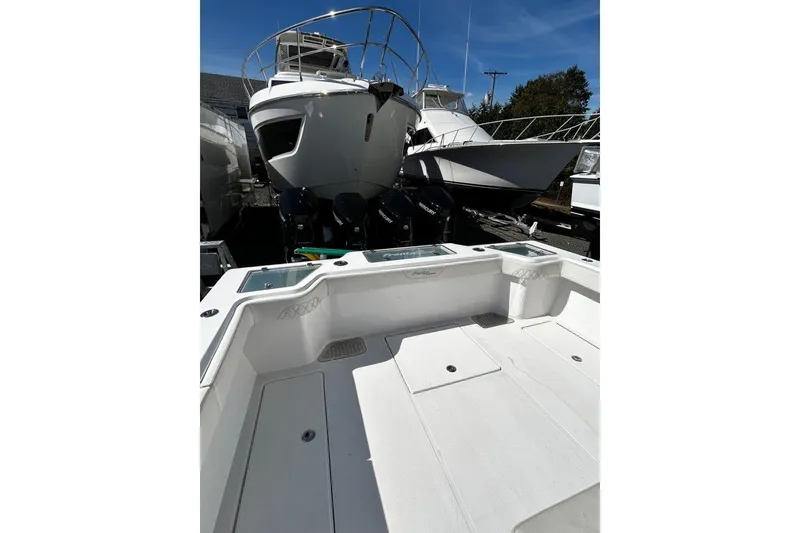 Slide: The Image of 2023 Front Runner 39 Center Console boat with multiple outboard engines, docked under clear sky. - 7
