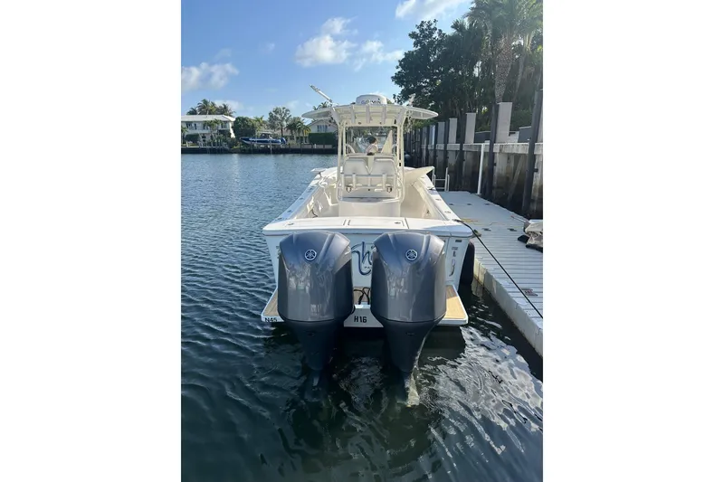 Slide: The Image of 2017 Regulator 28 boat with dual outboard engines docked in a serene marina. - 7