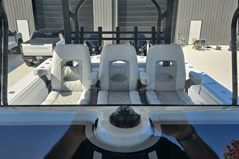 Slide: The Image of 2025 Costa Custom Boats 34ST interior with three white seats and outdoor setting. - 34