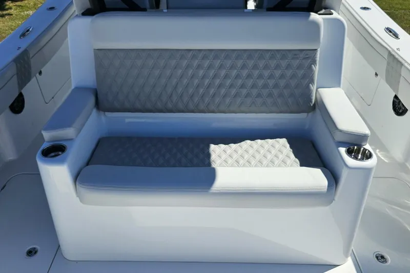 Slide: The Image of Luxurious seating on 2025 Costa Custom Boats 34ST, featuring diamond-patterned upholstery and cup holders. - 51