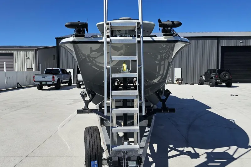 Slide: The Image of 2025 Costa Custom Boats 34ST on trailer, parked in industrial area under clear blue sky. - 8