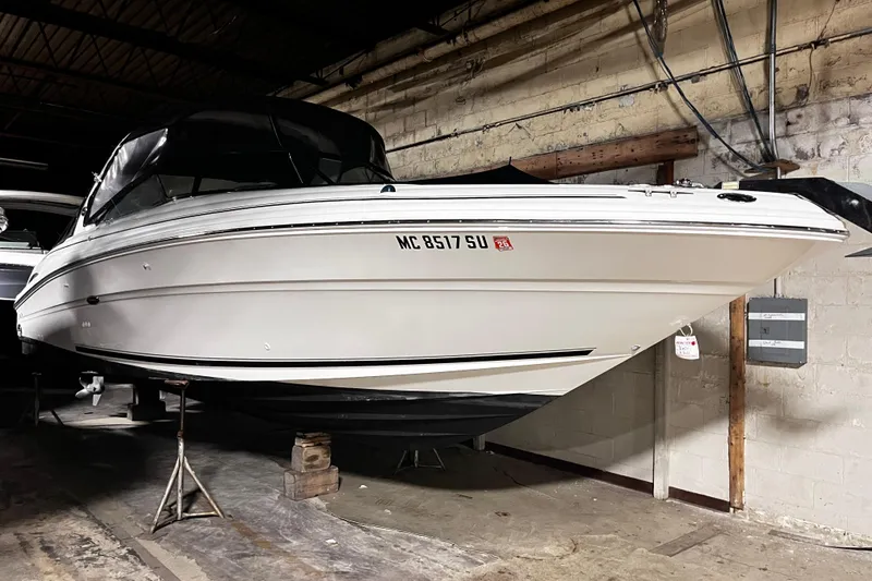 The Image of 2004 Sea Ray 290 Bowrider boat in indoor storage, elevated on stands. - 0