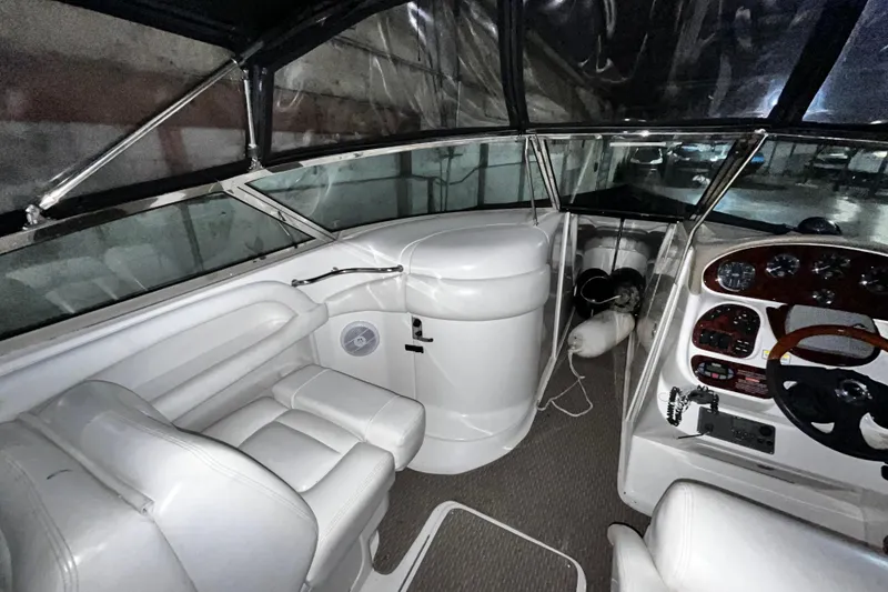 Slide: The Image of 2004 Sea Ray 290 Bowrider cockpit with white seating and control panel. - 12
