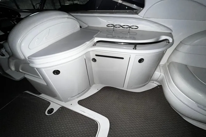 Slide: The Image of 2004 Sea Ray 290 Bowrider interior with sleek white cabinetry and seating. - 14