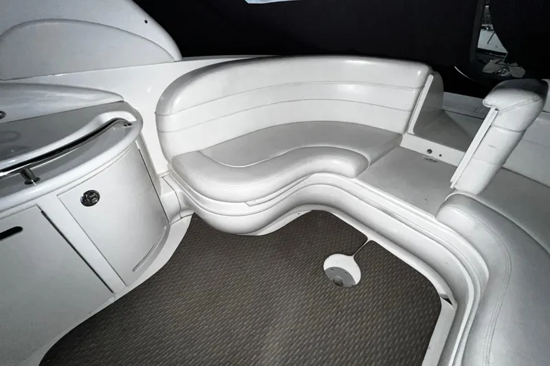 Slide: The Image of 2004 Sea Ray 290 Bowrider interior with white seating and carpeted floor. - 15