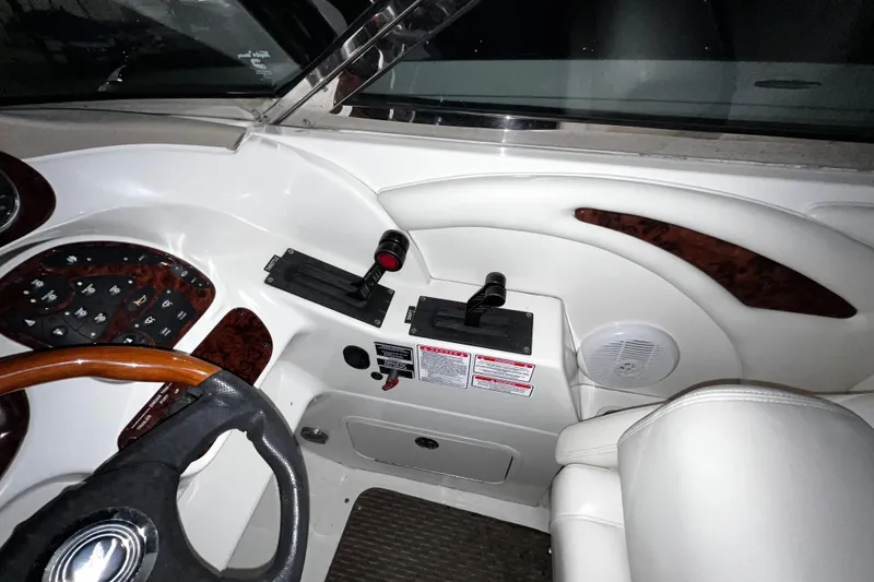 Slide: The Image of 2004 Sea Ray 290 Bowrider cockpit with steering wheel and control panel. - 17