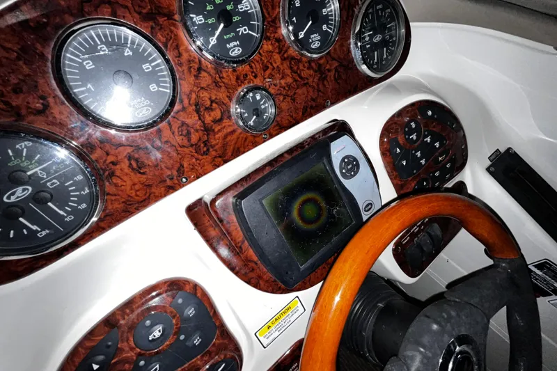 Slide: The Image of Dashboard of a 2004 Sea Ray 290 Bowrider with wood accents and gauges. - 18