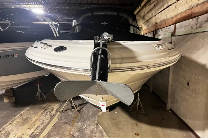 Slide: The Image of 2004 Sea Ray 290 Bowrider boat stored indoors, front view with anchor visible. - 2