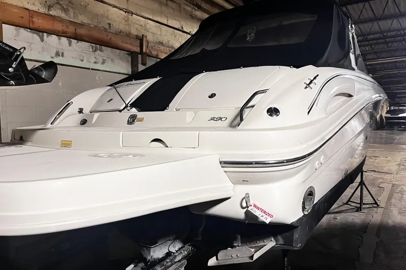 Slide: The Image of 2004 Sea Ray 290 Bowrider boat in storage, featuring sleek white design. - 3