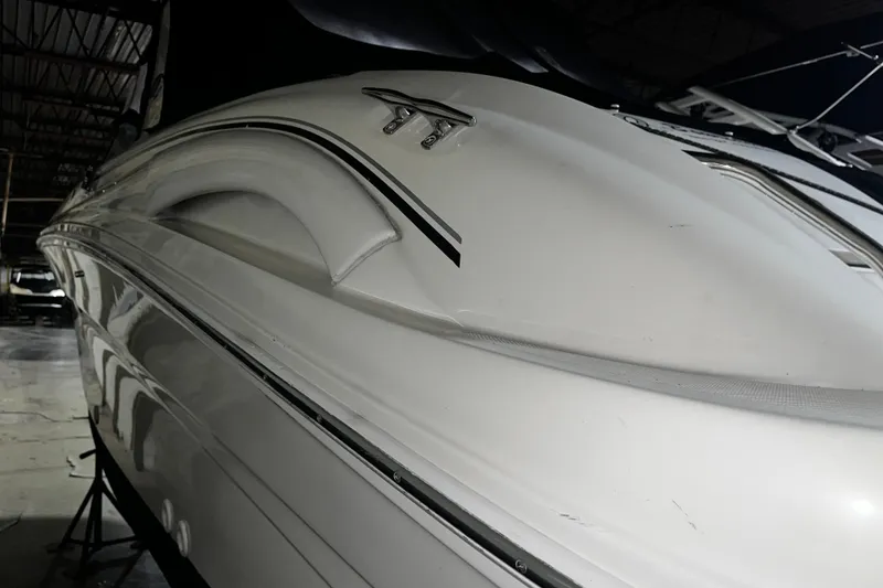 Slide: The Image of 2004 Sea Ray 290 Bowrider boat in storage, showcasing sleek white hull design. - 7