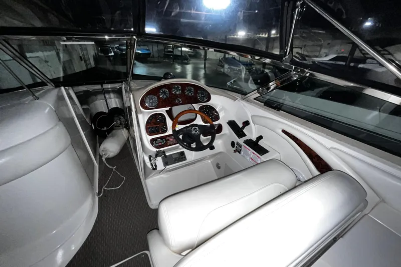 Slide: The Image of 2004 Sea Ray 290 Bowrider cockpit with steering wheel and control panel. - 9
