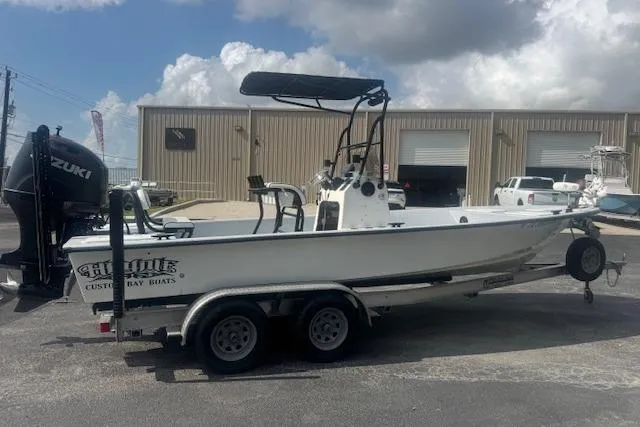 Slide: The Image of 2007 Haynie 23 Bigfoot boat on trailer, parked outside industrial building under cloudy sky. - 2