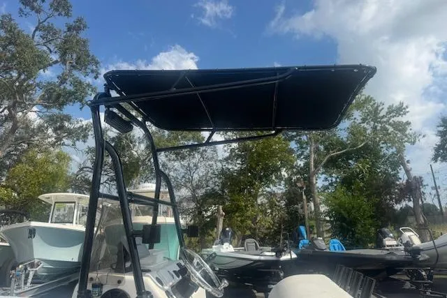 Slide: The Image of 2007 Haynie 23 Bigfoot boat with canopy, parked outdoors under a blue sky. - 20