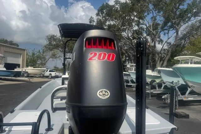 Slide: The Image of 2007 Haynie 23 Bigfoot boat with powerful 200 HP engine, parked outdoors. - 4