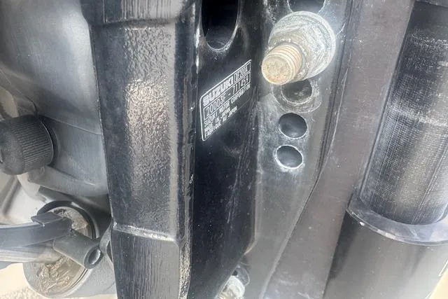 Slide: The Image of Close-up of a 2007 Haynie 23 Bigfoot boat engine component with visible bolts and label. - 8