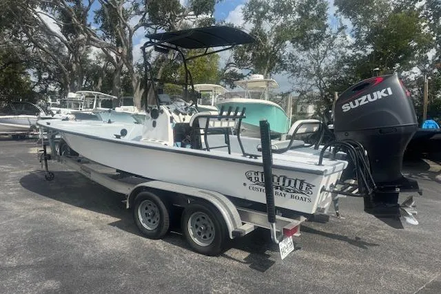 Slide: The Image of 2007 Haynie 23 Bigfoot boat with Suzuki engine on a trailer in a parking lot. - 9