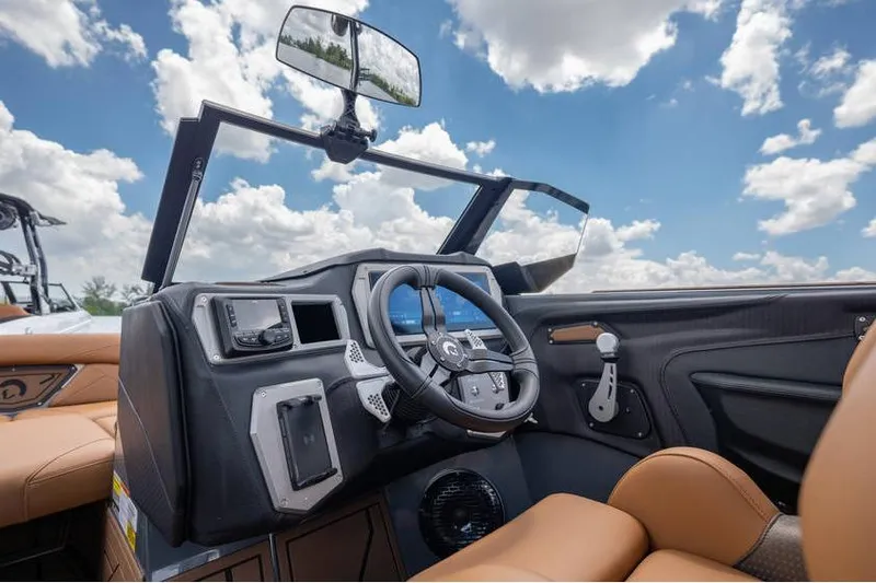 Slide: The Image of 2025 Centurion Nv233 boat interior with modern dashboard and steering wheel under blue sky. - 31