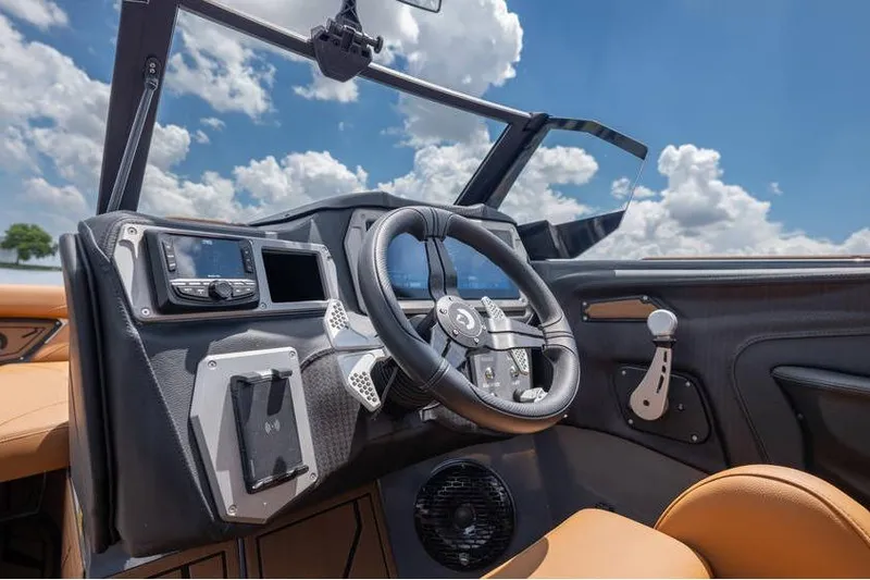 Slide: The Image of 2025 Centurion Nv233 boat dashboard with steering wheel, modern controls, and clear sky background. - 32