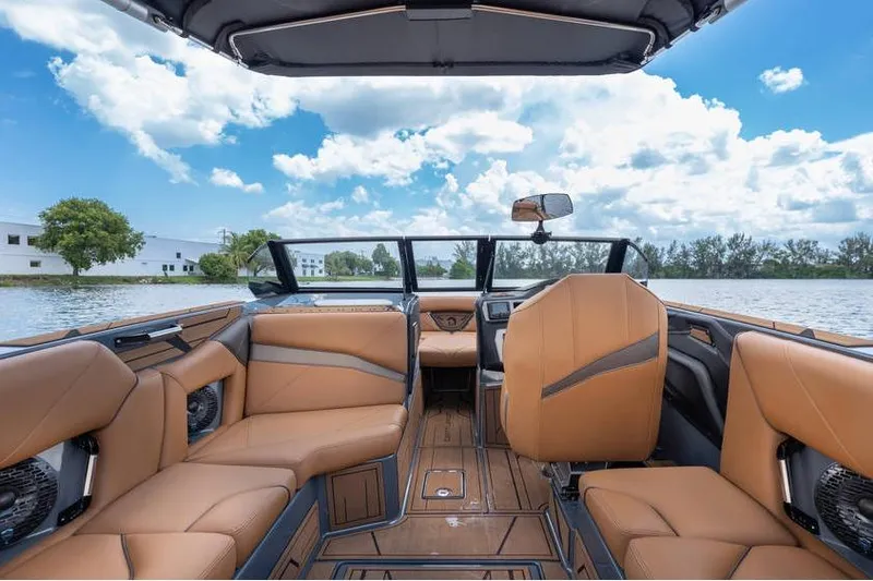 Slide: The Image of Interior of 2025 Centurion Nv233 boat with luxurious tan seating and scenic water view. - 42