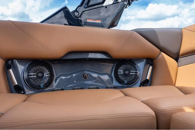 Slide: The Image of 2025 Centurion Nv233 boat interior with premium speakers and tan leather seating. - 43