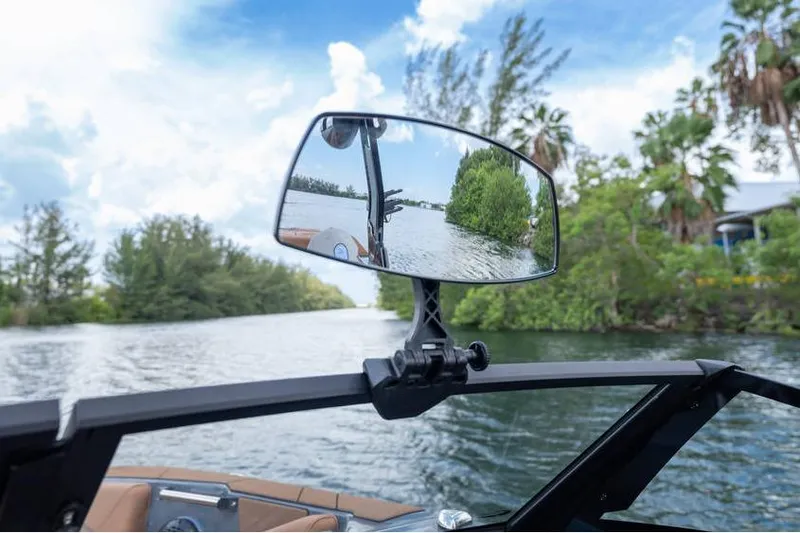 Slide: The Image of Rearview mirror on Centurion Nv233 boat reflecting scenic waterway, 2025 model. - 44