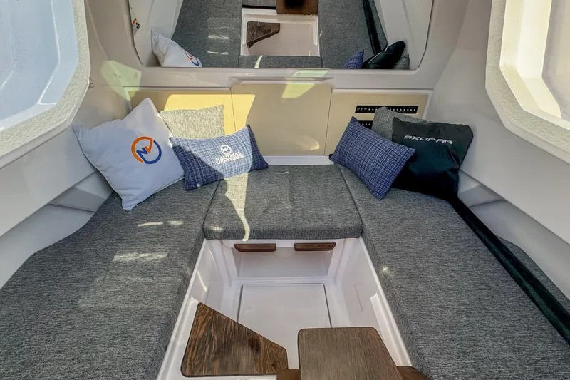 Slide: The Image of 2026 Axopar 29 Sun Top interior with gray seating and decorative pillows. - 12