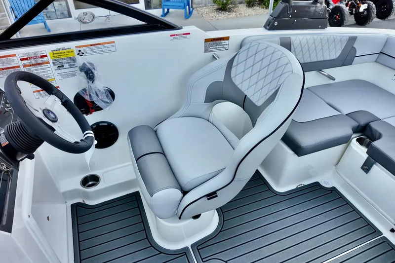 Slide: The Image of 2025 Bayliner VR4 Bowrider OB interior with steering wheel and cushioned seating. - 11