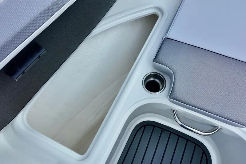 Slide: The Image of 2025 Bayliner VR4 Bowrider OB interior with storage compartment and cup holder. - 9