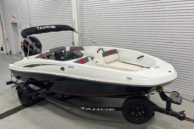 The Image of 2020 Tahoe T16 boat with trailer, white and black design, in a showroom setting. - 0