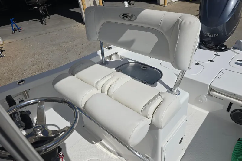 Slide: The Image of 2017 Sea Hunt BX 25 BR boat interior with white cushioned seating and steering wheel. - 10