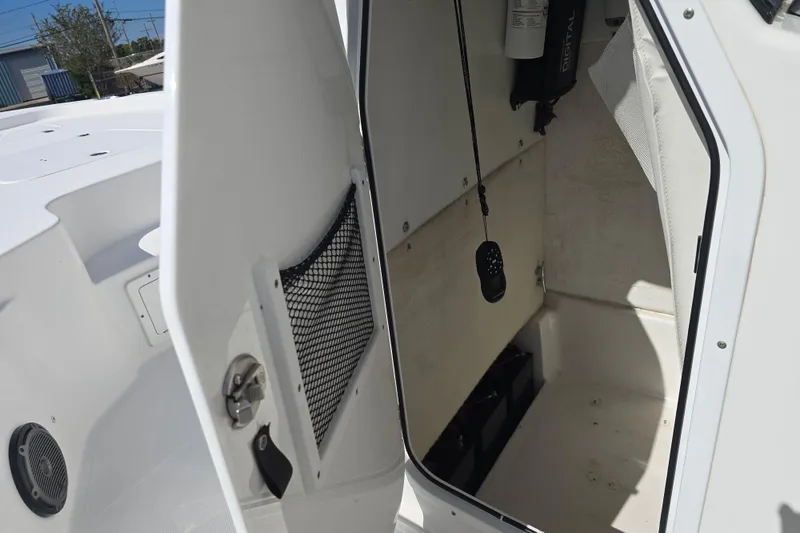 Slide: The Image of 2017 Sea Hunt BX 25 BR boat storage compartment with open door and interior view. - 14