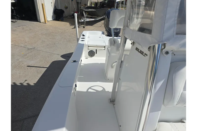 Slide: The Image of 2017 Sea Hunt BX 25 BR boat interior with seating and console, docked outdoors. - 17
