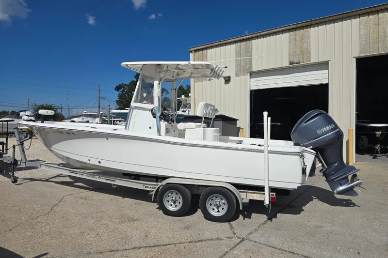 Slide: The Image of 2017 Sea Hunt BX 25 BR boat on trailer with Yamaha outboard motor, parked outside a warehouse. - 2