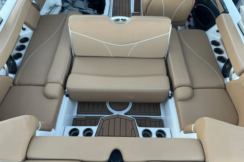 Slide: The Image of 2021 MasterCraft XT21 boat interior with tan seating and cup holders. - 10