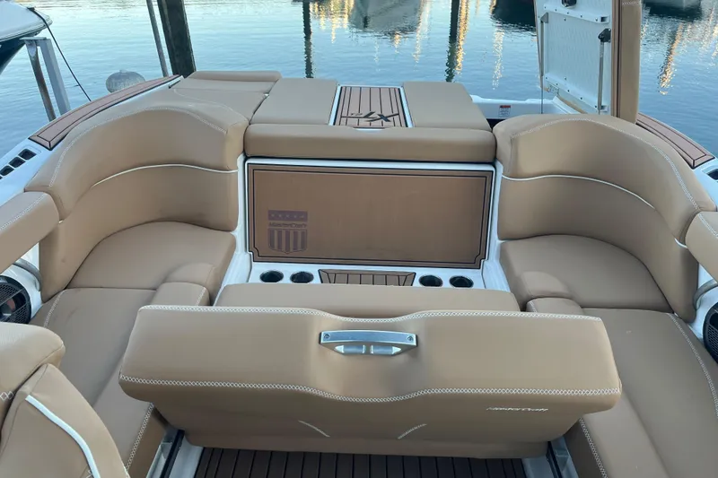 Slide: The Image of 2021 MasterCraft XT21 boat interior with tan seating and cup holders. - 11