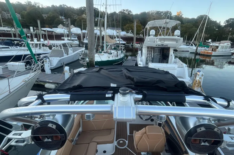 Slide: The Image of 2021 MasterCraft XT21 boat docked in a marina with surrounding yachts. - 14