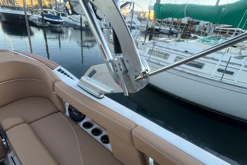 Slide: The Image of 2021 MasterCraft XT21 boat interior with tan seating, docked at marina. - 15